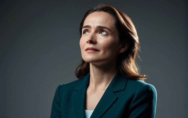 A professional female actress, in a mid-shot, gracefully conveying a range of subtle emotions through her expressive face and natural pose. She is wearing modest, elegant, and stylish professional attire, fully clothed. The setting is a minimalist stage with soft, dramatic lighting that highlights her features, and the background is softly blurred to emphasize the performer. Perfect anatomy, correct proportions, well-formed hands, proper finger count, natural body proportions, high-quality cinematic photography, shallow depth of field, professional lighting, film grain, safe for work, appropriate content, fully clothed, professional.